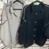 Erlebe deinen Style neu mit den Luna Strickjacken - in Beige und Schwarz für dich, modern inszeniert vor Backsteinwand.