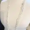 Entdecke die "Glanzmomente" Kette: Funkelnde Kristalle & edle Perlen, auf weißem Mannequin - dein Statement für glamouröse Looks!.