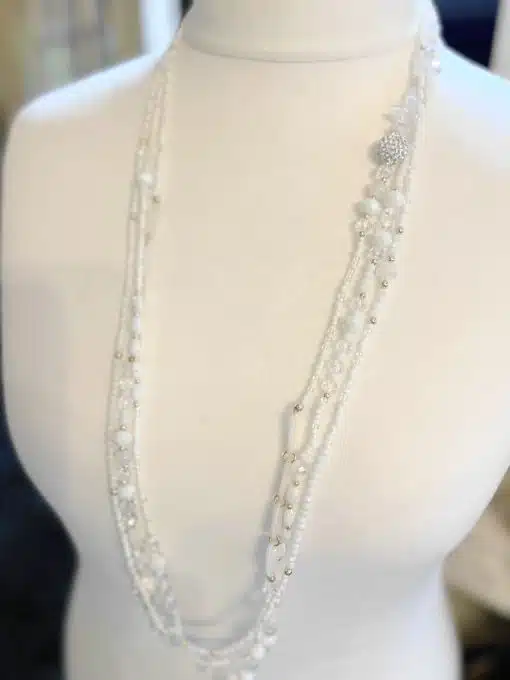 Entdecke die "Glanzmomente" Kette: Funkelnde Kristalle & edle Perlen, auf weißem Mannequin - dein Statement für glamouröse Looks!.