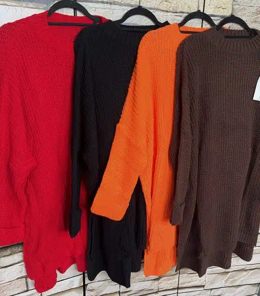 Hol dir den Cozy Glow! Vier trendige Strickpullover in Rot, Schwarz, Orange und Braun warten an der Backsteinwand auf dich.
