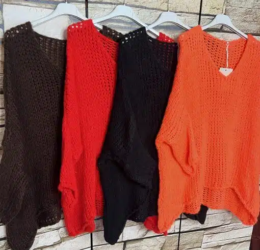 Entdecke deinen Style: Vier lässige Strickpullover in Braun, Rot, Schwarz und Orange - trendy vor urbaner Backsteinwand.