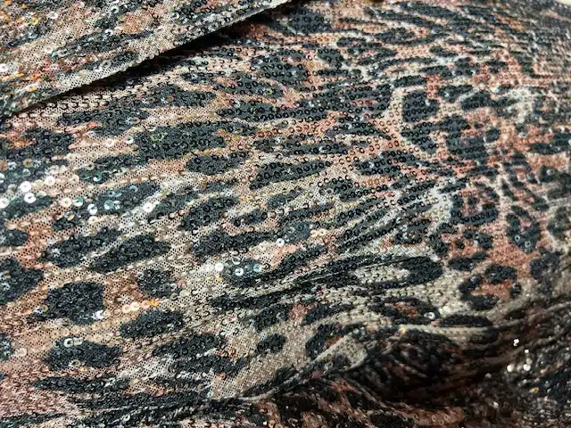 Entdecke das funkelnde Leopardenmuster in Braun, Schwarz und Gold - dein Statement-Piece für pure Urban-Glamour-Vibes!.