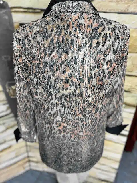 Erlebe deinen Wow-Moment: Der Urban Glam Blazer mit Animal-Print & Pailletten rockt die Schaufensterpuppe vor Steinwand.