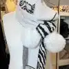 Setz mit dem Wildlook Schal ein Statement: Weich, weiß, zebra-gemustert und mit flauschigen Pom-Poms - dein Hingucker!.