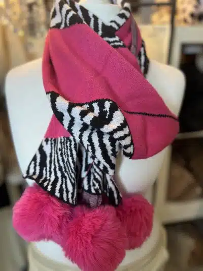 Mit dem Wildlook Schal wirst du zum Trendsetter: Weicher Strick, Animal-Print und pinke Kunstfell-Bommel, stylisch präsentiert.
