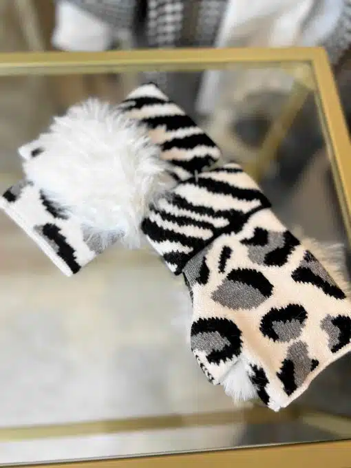 Erlebe deinen Style: Wildlook Handstulpen mit passendem Animal-Print-Schal, modern inszeniert auf glänzendem Glas.
