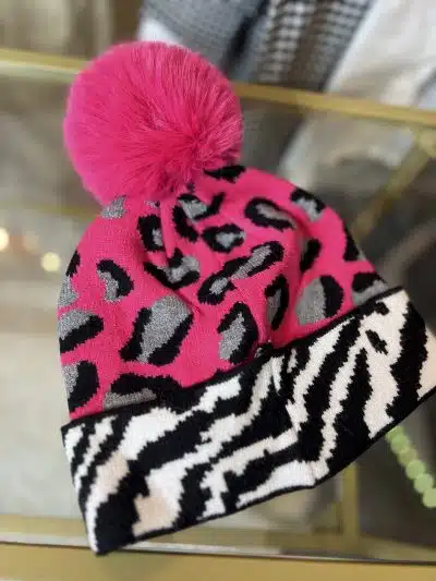 Setzen Sie ein echtes Fashion-Statement mit der Wildlook Mütze im pinken Leo-Print und trendigem Kunstfell-Pompon!.