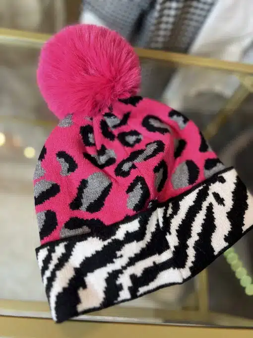 Setzen Sie ein echtes Fashion-Statement mit der Wildlook Mütze im pinken Leo-Print und trendigem Kunstfell-Pompon!.