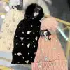 Verleihe deinem Look das gewisse Etwas: Die Winterzauber-Mütze mit Kristallen und Pompon gibt's in Creme, Schwarz oder Pink!.