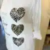 Lass dich von diesem weißen Shirt mit drei trendigen Herzen begeistern: Leo-, Zebra-Print und glitzerndes Silber - dein Must-have!.
