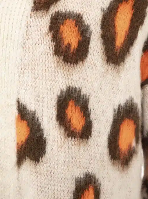 Erlebe den Zwillingsherz Kuschel-Cardigan "Soft Leo": Flauschiges Creme-Gestrick und stylischer Leo-Look in Orange und Schwarz.