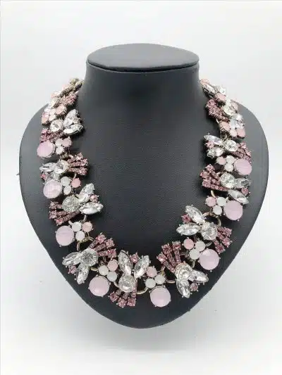 Erlebe The Romantic Shine - ein edles Kristallcollier mit pinken, weißen und klaren Blütenkristallen auf schwarzem Display.