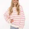 Mit deinem strahlenden Lächeln und dem stylishen pink-weiß gestreiften Sweater setzt du ein modernes Fashion-Statement.