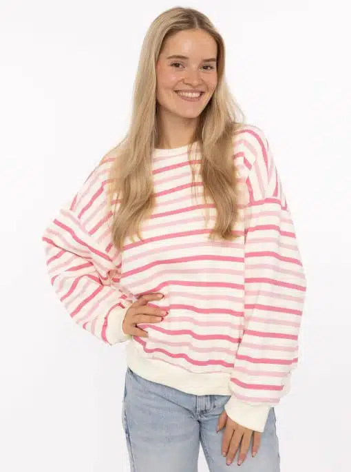Mit deinem strahlenden Lächeln und dem stylishen pink-weiß gestreiften Sweater setzt du ein modernes Fashion-Statement.