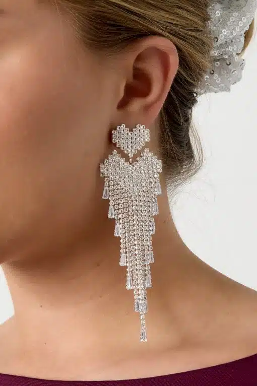 Setzen Sie ein Statement mit diesem opulenten, silbernen Kristall-Chandelier-Ohrring und dem glänzenden Pailletten-Haar-Accessoire.