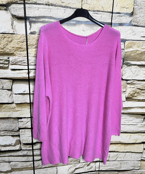 Erlebe pure Weichheit: Der lässig geschnittene Pure Softness Pullover in Pink wartet auf dich - lässig inszeniert vor Steinwand.