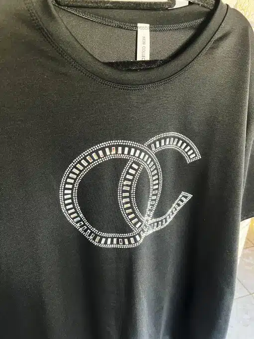 Erlebe pure Eleganz: Dein schwarzes Glam Top mit auffälligen, funkelnden Strass-C's - perfekt für einen starken Auftritt!.