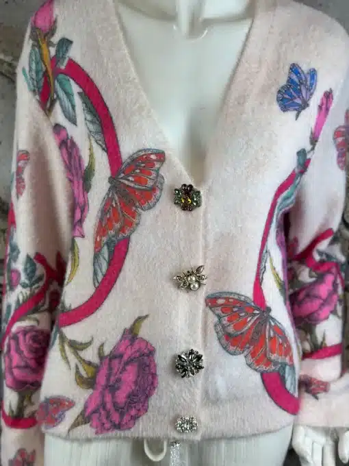 Entdecke deinen neuen Look: Zieh den zarten Butterfly Bloom Cardigan mit floralen Mustern und funkelnden Knöpfen an!.