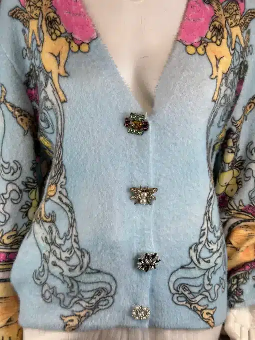 Hol dir den Baroque Angel Cardigan - hellblau, mit angesagtem Barockmotiv und vier edlen Schmuckknopf-Insekten!.