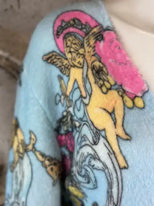 Erlebe den Baroque Angel Cardigan aus blauem Stoff - mit farbenprächtigem Cherub- und Blumenmuster, stilvoll inszeniert.