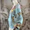 Erlebe den Baroque Angel Cardigan an einem edlen Mannequin mit stilvollen Pastellmustern vor prachtvollem Barock-Setting.