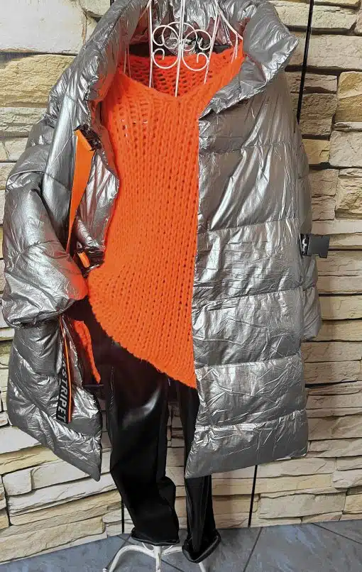 Erlebe den urbanen Look: Du trägst unsere silberne Oversize-Jacke, leuchtende Orangepulli und schwarze Pants.