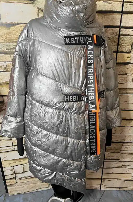 Hol dir den auffälligen Look: Die THE BLACK STRIPE Oversize-Jacke in metallic Silber, mit stylishen Logo-Straps und orangefarbenem Akzent.