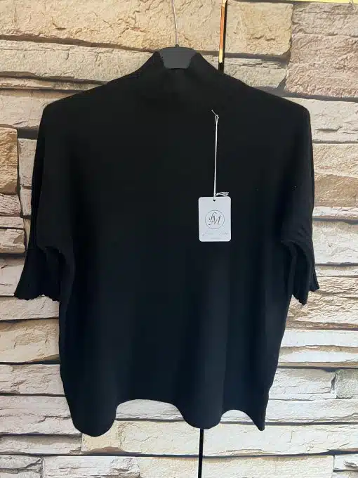 Erlebe zeitlose Eleganz: Hol dir den Élégance Classique Pullover - dein Statement in Schwarz vor trendigem Ziegelmuster-Hintergrund.