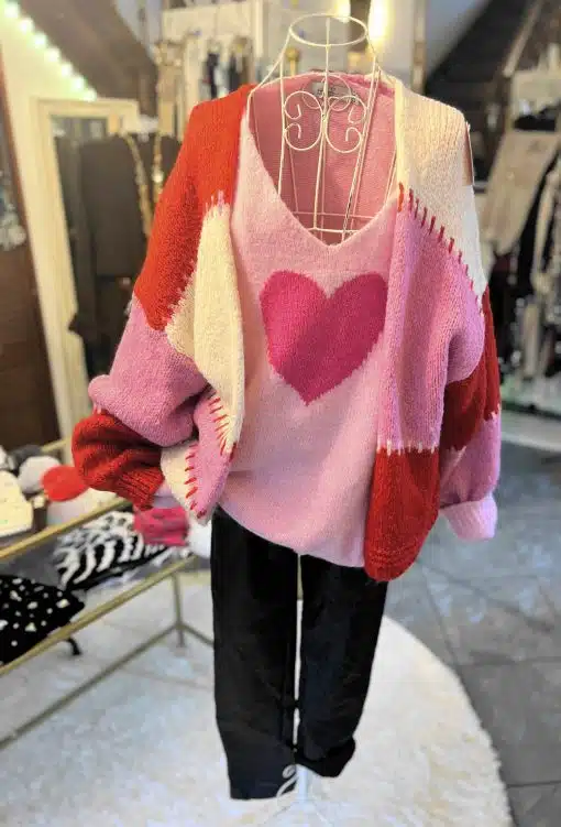 Entdecke deinen Look: Schwarze Hose, pinker Sweater mit Herz und die stylische Color Block Kuschel-Strickjacke in Rot-Pink!.