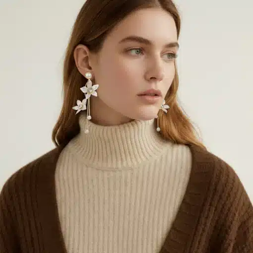 Erlebe deinen modernen Style: Beige Rollkragenpullover, braune Strickjacke, auffällige florale Statement-Ohrringe.