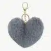Entdecke deinen grauen, flauschigen Herz-Schlüsselanhänger mit goldenem Ring - ein stylisches It-Piece für deine Tasche!.