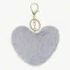 Mach dein Accessoire-Game einzigartig: Hänge dir das flauschige, graue Plüsch-Herz mit stylischem Goldring an deine Tasche!.