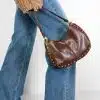 Du trägst flared Jeans, stylische Boots und präsentierst deine braune Nieten-Handtasche zum angesagten Strickpulli.