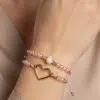 Erlebe den Style: Du trägst die Zwillingsherz Love Bracelet Twins - zwei rosa Perlenarmbänder mit Herz und Perle.