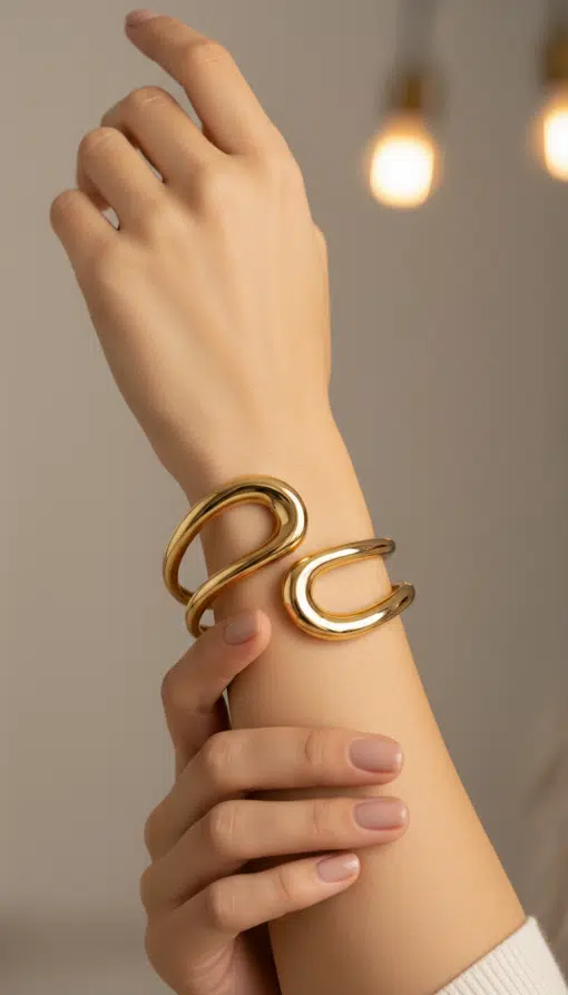 Setze dein Statement: Deine perfekt gepflegten Nägel glänzen mit der Golden Deluxe Armspange vor funkelndem, modernem Hintergrund.