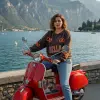 Setz dich auf deinen roten Scooter, trag das trendige Bella Ciao Sweatshirt und genieße den Seeblick vor Bergkulisse.