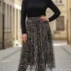 Setze ein Fashion-Statement: Im schwarzen Top, Urban Jungle Chiffonrock und Boots rockst du die Kopfsteinpflaster-Straße!.