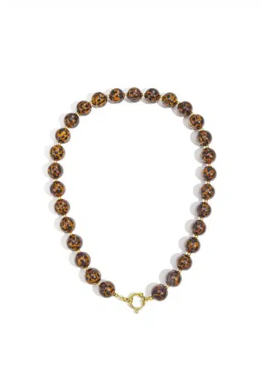 Entdecke deine neue Lieblingskette: Runde Perlen im trendigen Tortoise-Look und ein glänzender Goldverschluss - stylisch arrangiert.