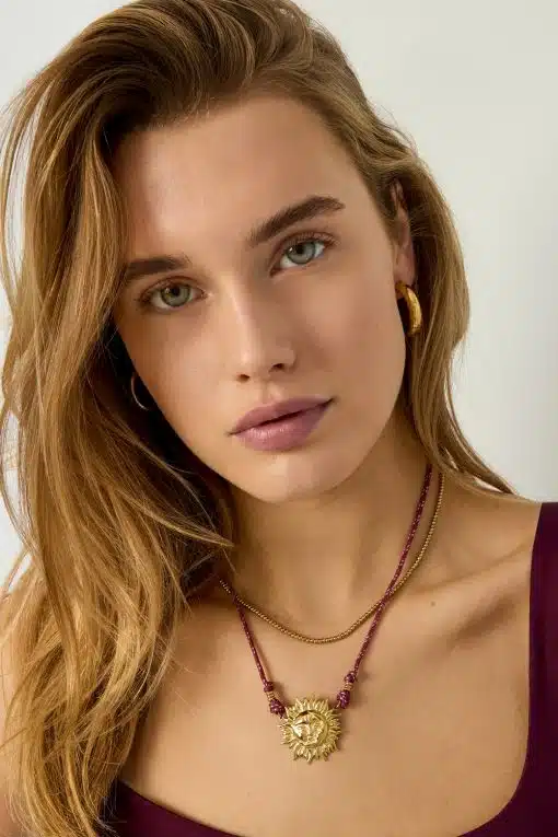 Strahle stilvoll: Trage goldene Creolen, eine elegante Kette und The Sun Kette - ein Sonnenanhänger am bordeauxroten Band.
