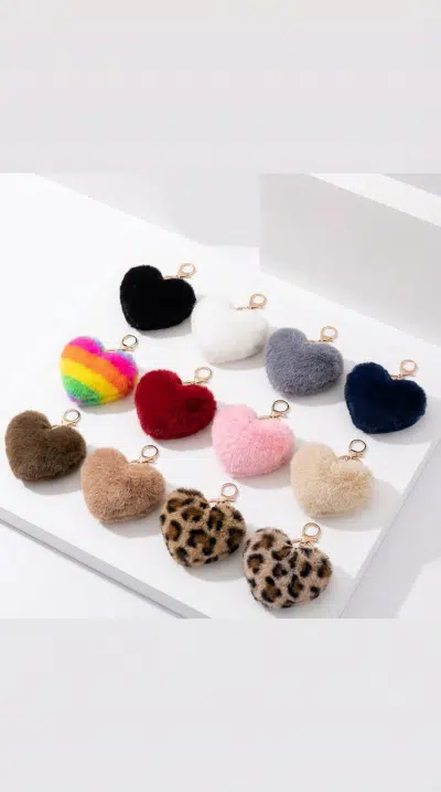 Entdecke zwölf trendige Plüsch-Liebes-Schlüssel- und Taschenanhänger in stylischen Farben und Mustern auf weißem Hintergrund!.