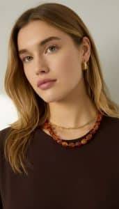 Retro-Bead Kette: Frau mit Halskette aus braunen Perlen und goldener Kette, Ohrringe. Modeschmuck.