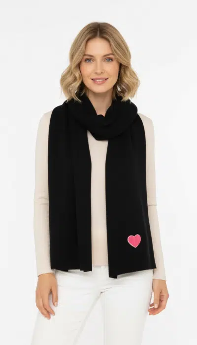 Spüre den Winterzauber: Trage den Zwillingsherz Winterliebe-Strickschal mit pinkem Herz, kombiniert zu Beige und Weiß.