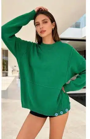 Du trägst den grünen Pure Ease Pullover mit stylischen Knopfdetails und schwarzen Shorts - lässig, modern und absolut im Trend.