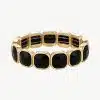 Erlebe, wie das goldene Armband mit markanten schwarzen Edelsteinen deinen Look modern und luxuriös in Szene setzt.