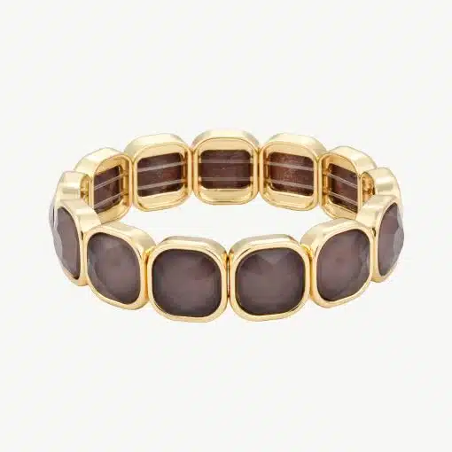 Erlebe Luxus am Handgelenk: Du trägst ein modernes Goldarmband mit quadratischen, funkelnden Braunsteinen im edlen Design.