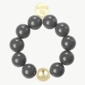 Setz ein Statement: Dein rundes Armband mit großen schwarzen Perlen, einem goldenen Akzent und "GINO"-Gravur