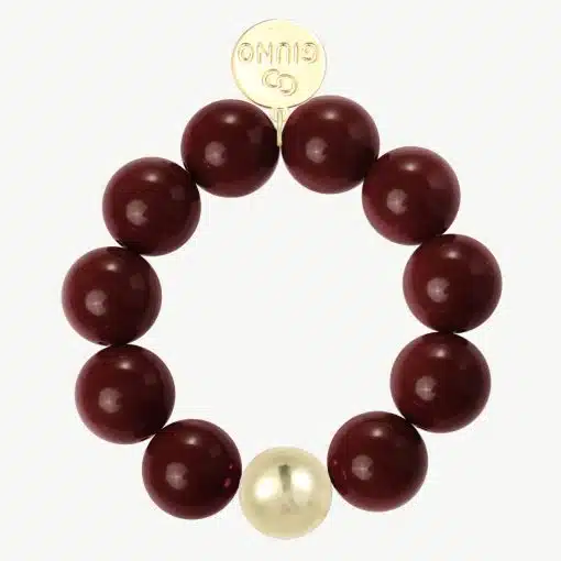 Erlebe das GIUNO-Armband: Kraftvolle bordeauxrote Perlen, ein goldener Akzent und gravierte Scheibe für deinen Signature-Look.