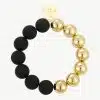 Erlebe deinen Style: Ein modernes Armband mit mattschwarzen und glänzend goldenen Perlen sowie rundem Goldanhänger.