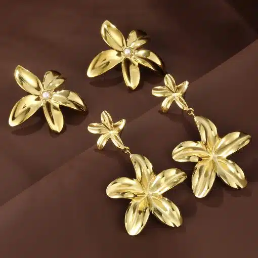 Entdecke jetzt die Aurelia Blossom Ohrstecker & Hänger in Gold - dein modernes Schmuck-Highlight strahlt elegant auf Braun.