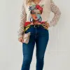 Setze ein Statement: Du rockst Jeans und Boots, trägst den Muse of Colors Pullover mit seinem knalligen Face-Design und eine beige Clutch.